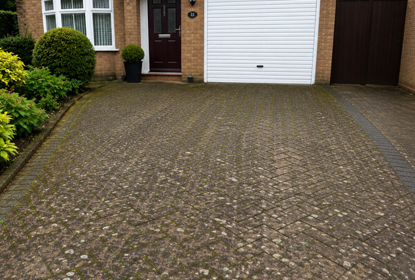 Driveway in Bedford before cleaning, with moss, dirt and darker weather marks