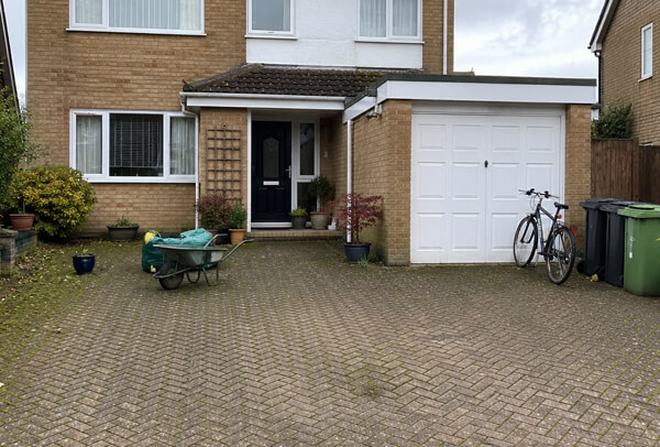 Driveway in Bedford before cleaning with outdoor items, surface dirt and moss
