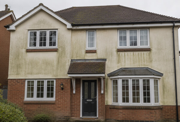 Bedford home exterior before washing with marked walls, dull details and algae staining