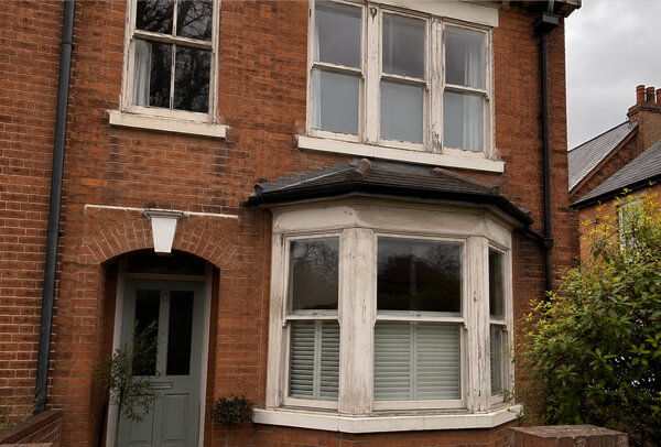 Exterior window frames in Bedford before painting, with faded and weathered surfaces