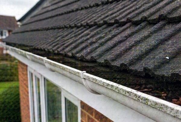 Gutters in Northampton before cleaning, blocked with debris and looking untidy