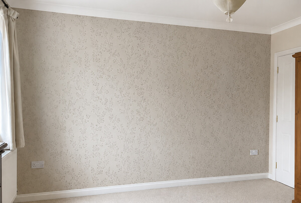 Bedroom wall in Hemel Hempstead after feature wallpaper with a neat patterned finish