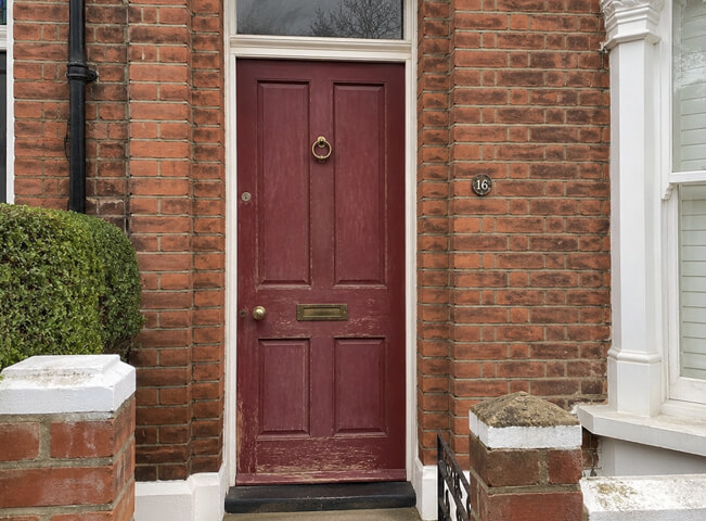 Entrance door before repainting with a dull and weathered finish