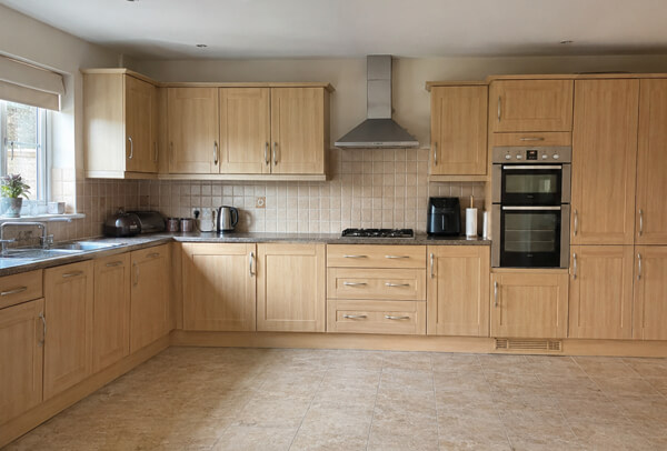 Kitchen photographed before a cupboard painting quote