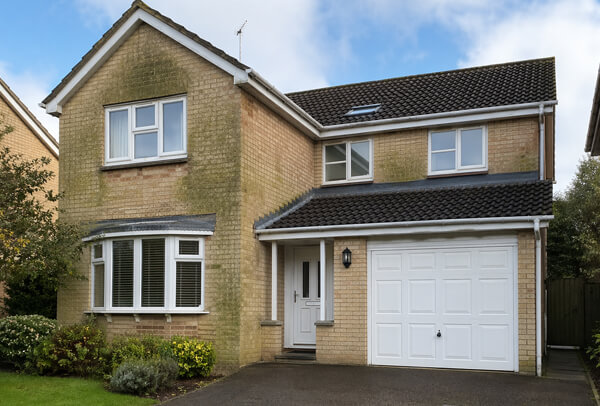 House exterior in Northampton before washing, with algae and dirt staining on the outside walls
