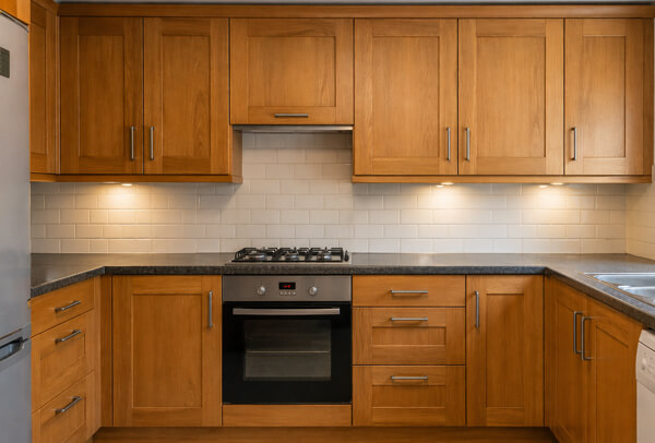 Kitchen cupboards in Northampton before painting, with dark dated doors and worn finishes