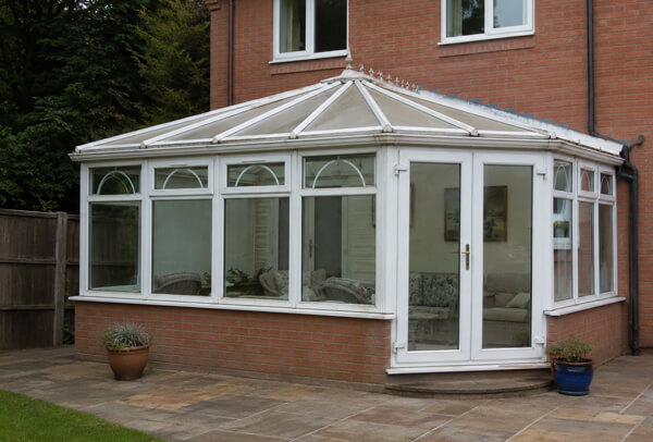 Garden view of conservatory frames before painting in Dunstable