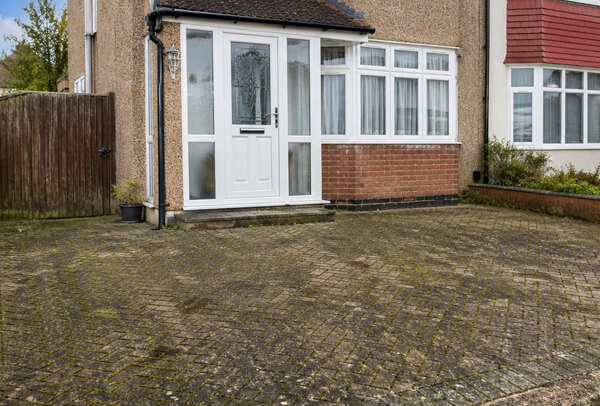Driveway in Luton before cleaning, showing moss, dirt and dark staining