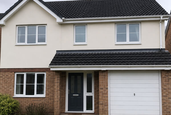 Exterior wall in Luton after cleaning green staining around windows and gutter line