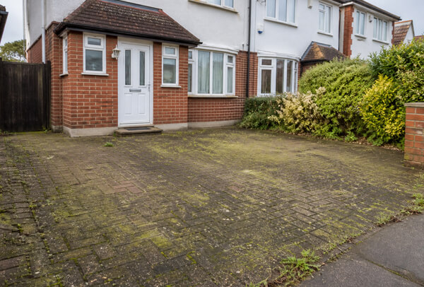 Driveway surface in Luton before cleaning with dull and weathered paving