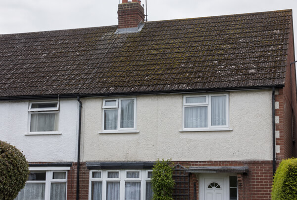 Roof cleaning in Luton before work with moss and dark staining visible from the front of the house
