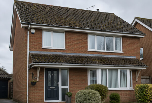 Roof and gutter area in Luton before cleaning with moss and debris near the roofline
