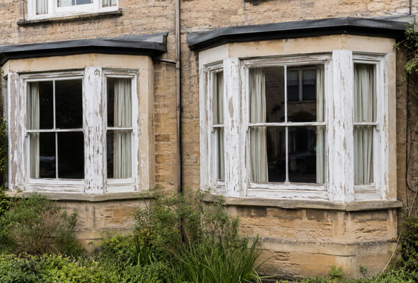 Exterior window frames in Oxford before painting, with faded and weathered surfaces