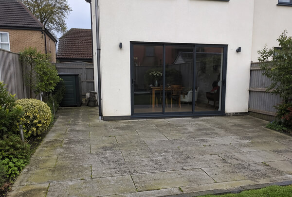 Patio in Northampton before deep cleaning, with organic staining and dirt build-up