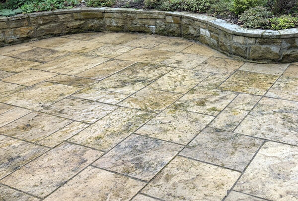 Patio before cleaning on sandstone and paving in Milton Keynes