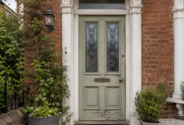 Older front door before repainting, showing a finish that no longer suits the home