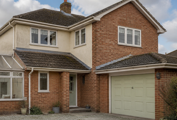 Home in Ampthill before exterior painting with faded frames garage door and roofline details